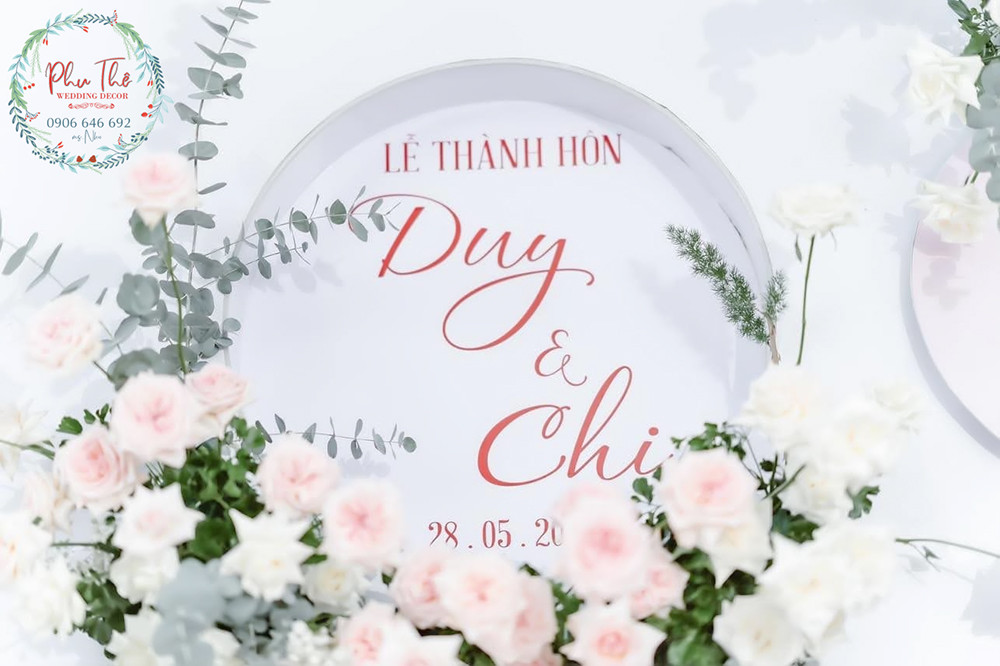Bàn thờ gia tiên trang trọng với hoa tươi và cổng hoa lụa lộng lẫy