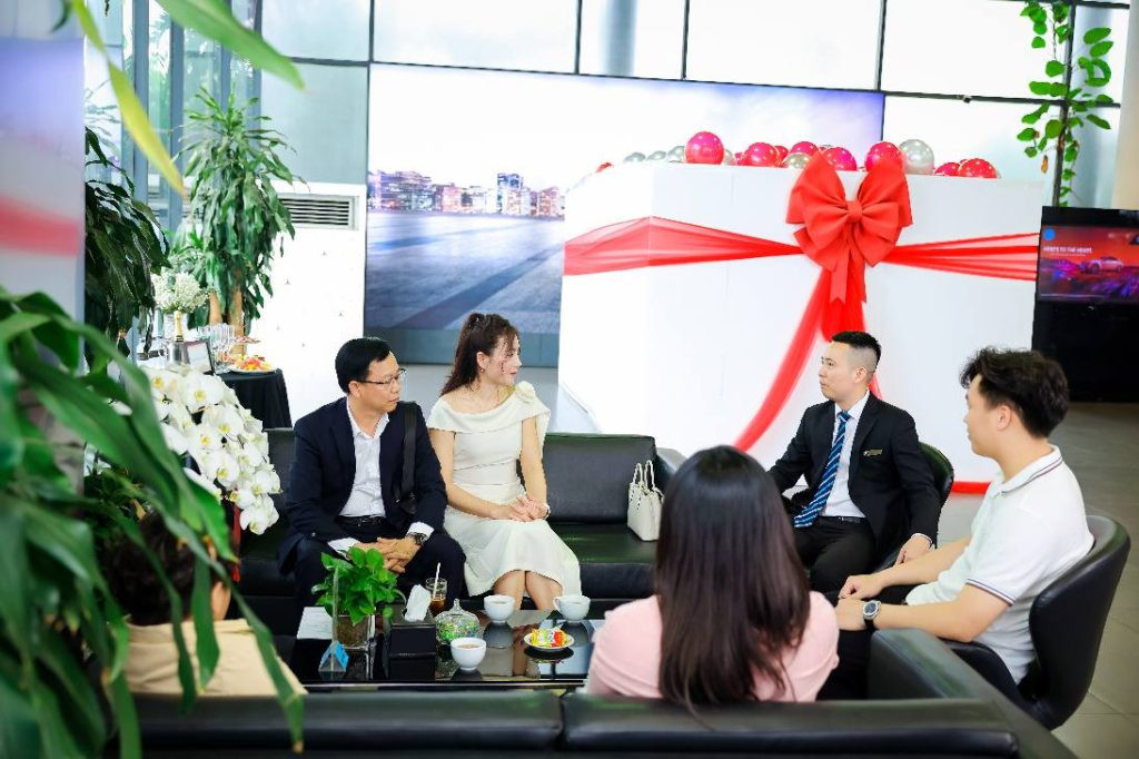 Đội ngũ kỹ thuật viên chuyên nghiệp đang lắp đặt khung hộp quà kính, đảm bảo sự hoàn hảo cho trang trí lễ bàn giao xe