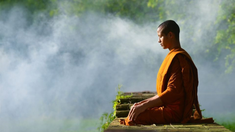 Một người đang thực hành thiền hoặc chánh niệm, thể hiện khả năng kiểm soát cảm xúc và giảm bớt sân si.