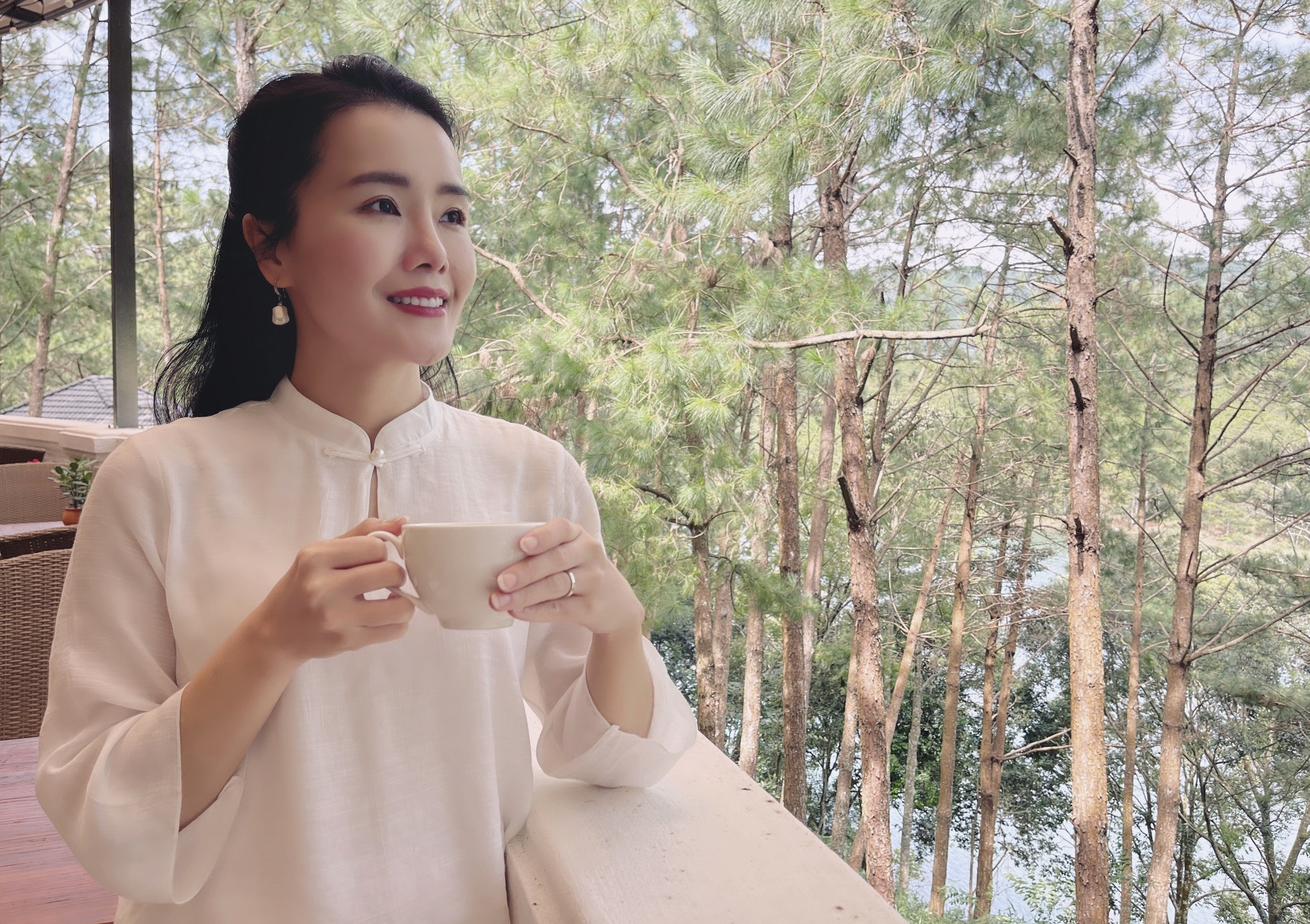 Một người phụ nữ đang ngắm nhìn cảnh biển hoàng hôn, tìm thấy bình yên trong không gian tự do và thanh thản.
