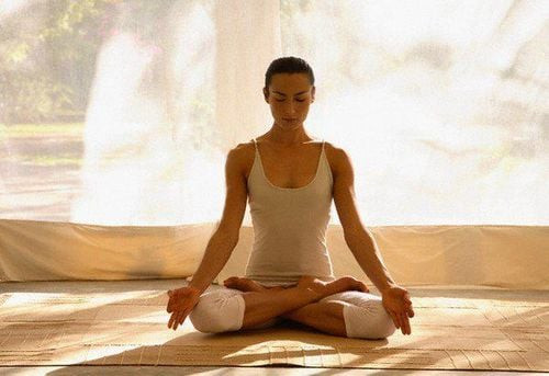 Một người phụ nữ ngồi thiền định trong tư thế hoa sen, thể hiện sự tập trung