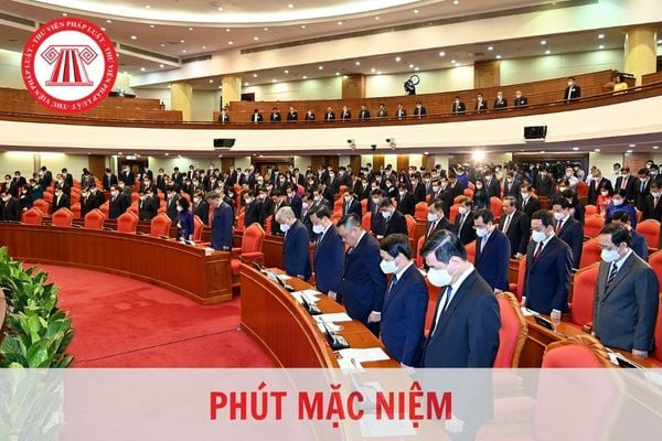 Một nhóm người tham gia nghi thức mặc niệm trong một buổi lễ trang trọng, thể hiện lòng tưởng nhớ và thành kính.