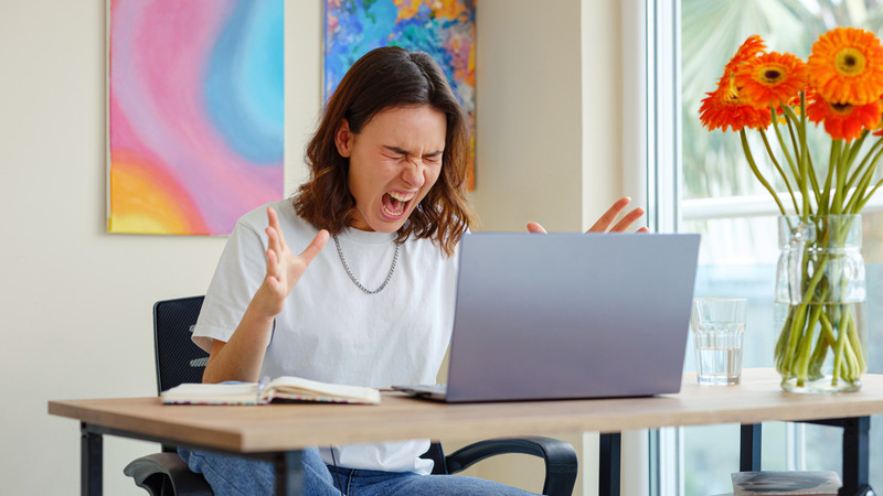 Người đàn ông làm việc căng thẳng, thể hiện sự cầu toàn và áp lực từ cảm giác bất an trong công việc.