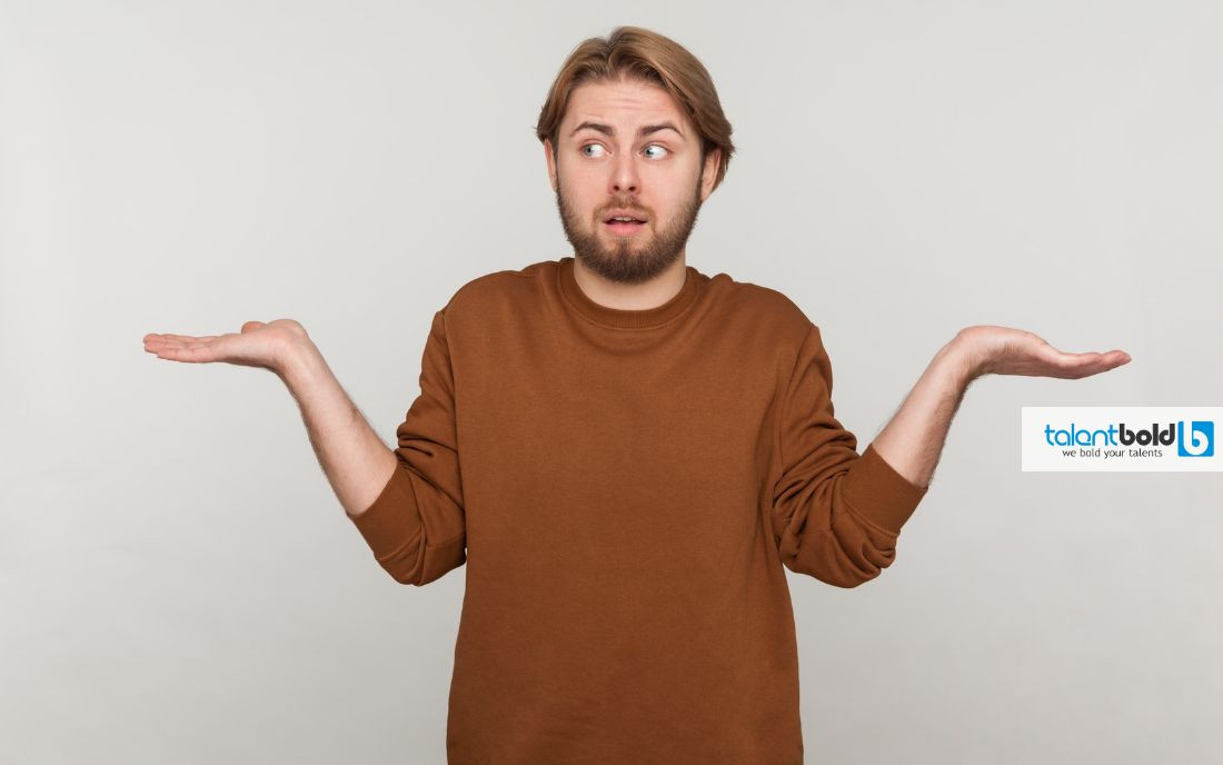 Người đàn ông trẻ đang ngồi gục mặt trên bàn làm việc, thể hiện sự áp lực và chênh vênh trong công việc