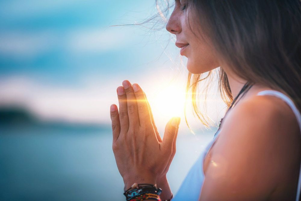 Người phụ nữ đang thiền định trong tư thế chánh niệm, toát lên sự bình yên và tập trung vào hiện tại.