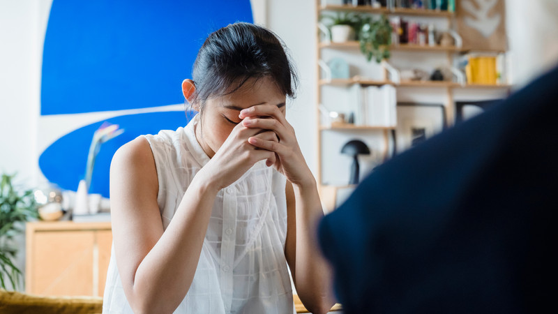 Người phụ nữ với vẻ mặt lo lắng, suy tư, thể hiện cảm giác bất an và băn khoăn về tương lai.