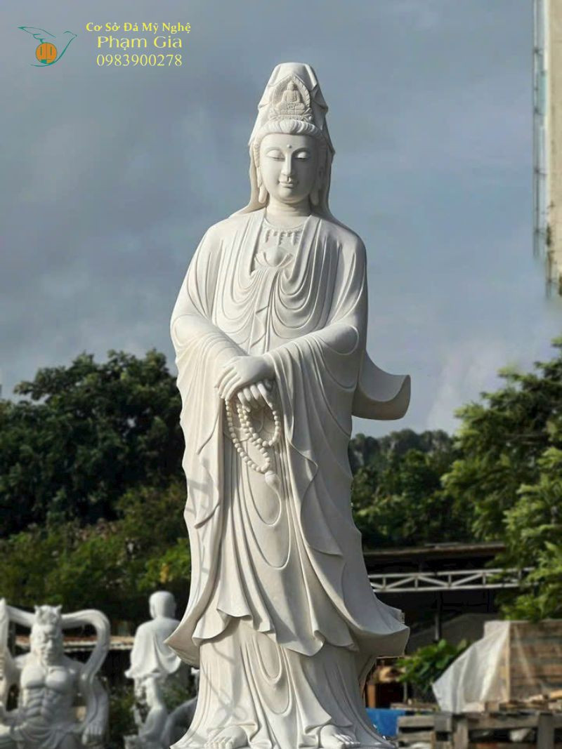 Tượng Quan Âm Bồ Tát bằng đá đứng trên đài sen, tay cầm bình cam lộ
